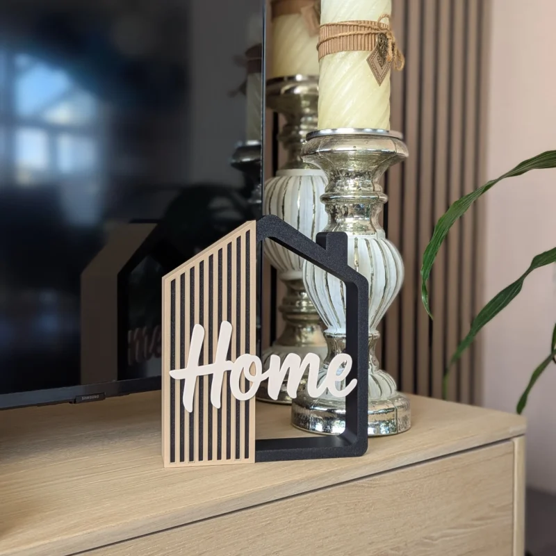 Casita decorativa Home impresa en 3D en negro, arena y crema, junto a unas velas