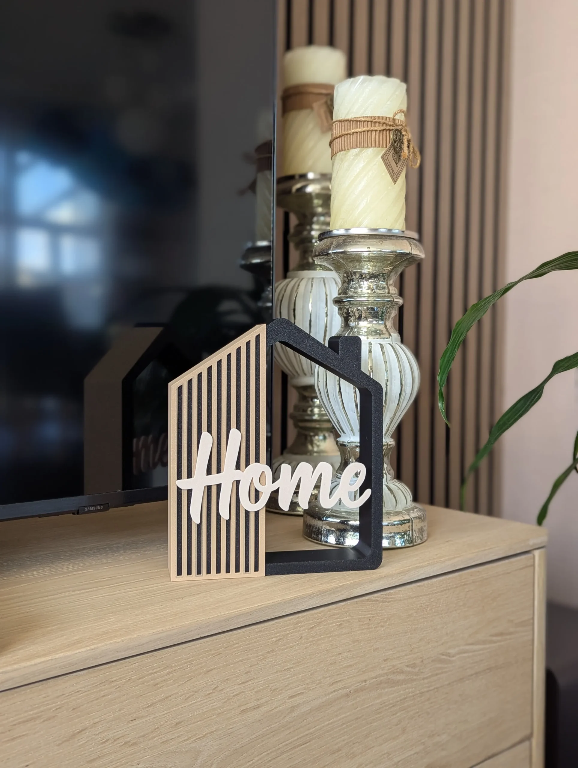 Casita decorativa Home impresa en 3D en negro, arena y crema, junto a unas velas