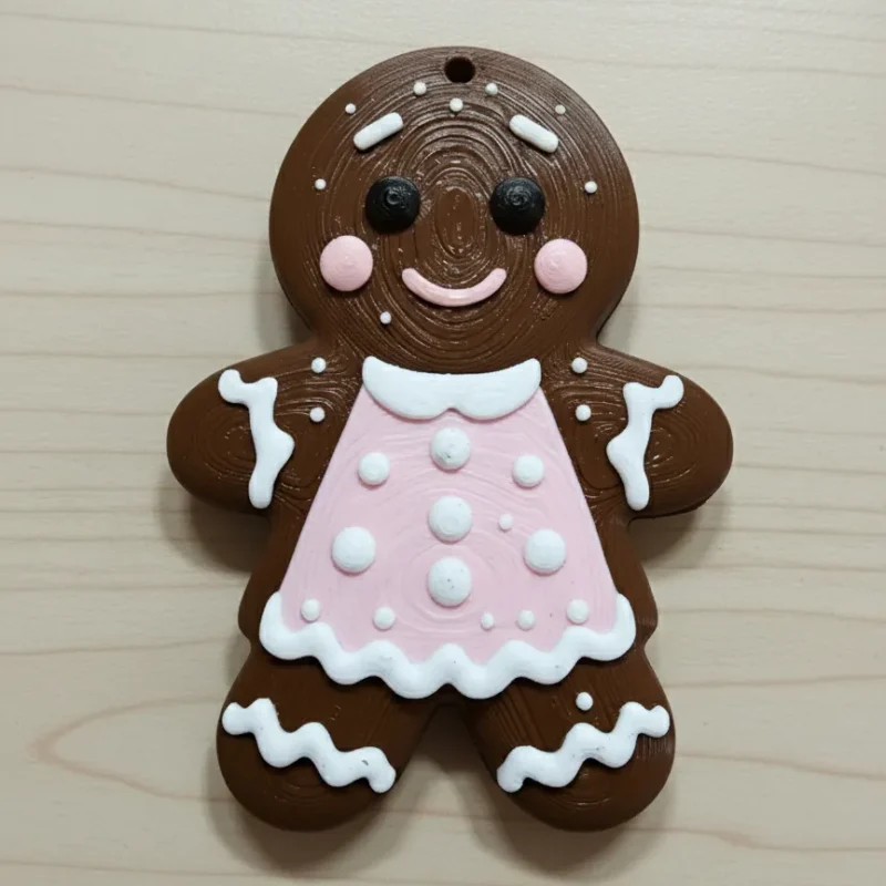 Adorno de galleta de jengibre marrón chocolate con vestido rosa y glaseado blanco