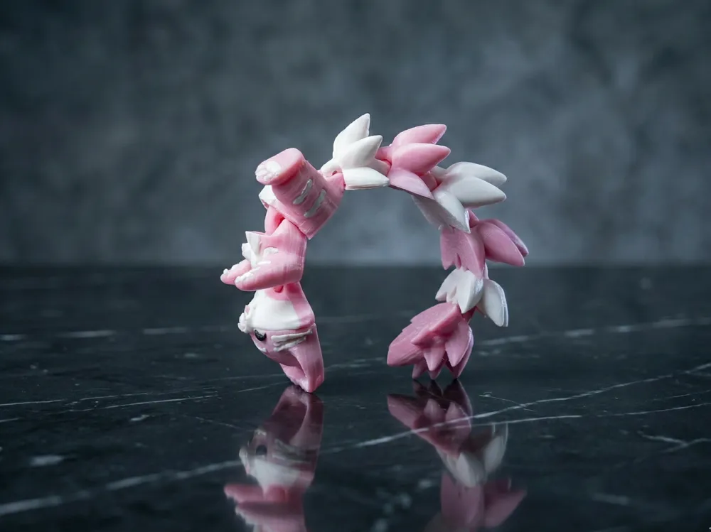 Llavero gato articulado curvado en arco mostrando la flexibilidad de su cola